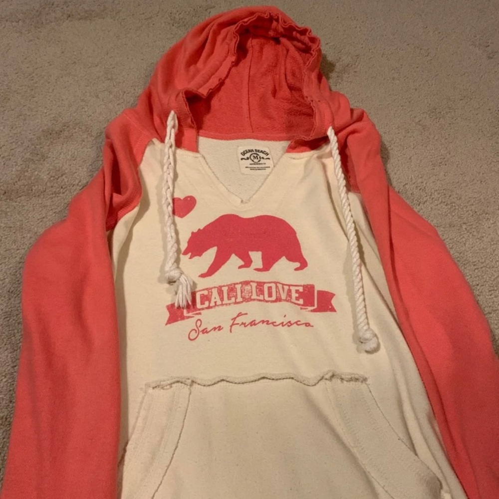 A pink and white sweatshirt. Cali Love/ San Fran